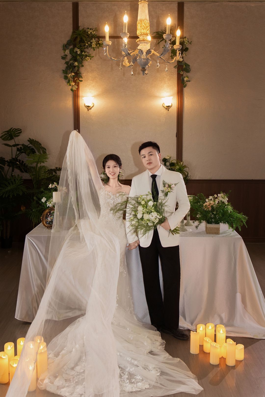 复古室内烛光下，新娘扬起头纱，与新郎牵手而立